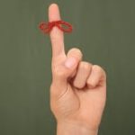 Stock reminder photo, index finger with red string bow tied to it.