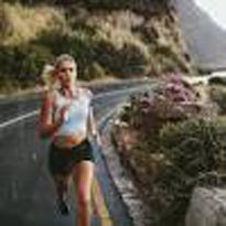 woman running down curvy mountain road